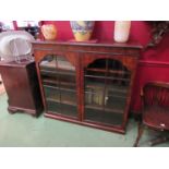 An 18th Century style figured walnut two door glazed bookcase on a plinth base (with key)