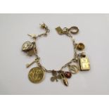 A gold and yellow metal charm bracelet set with 15 charms including half sovereign