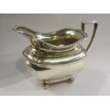 A Walker and Hall silver creamer, stirrup handle, plain form,