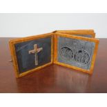 A leather bound book with engraved white metal plaques of the stations of the cross marked souvenir