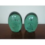 Two Victorian green glass dumps with bubble inclusions