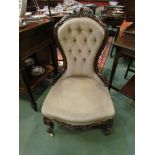 A Victorian carved rosewood button back open armchair on ceramic castors