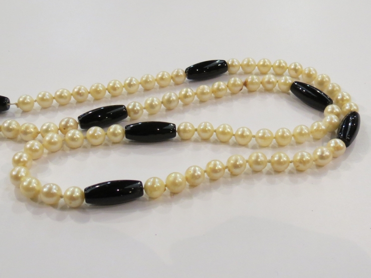 A cultured pearl necklace with glass bead dividers (appears to have one pearl missing)