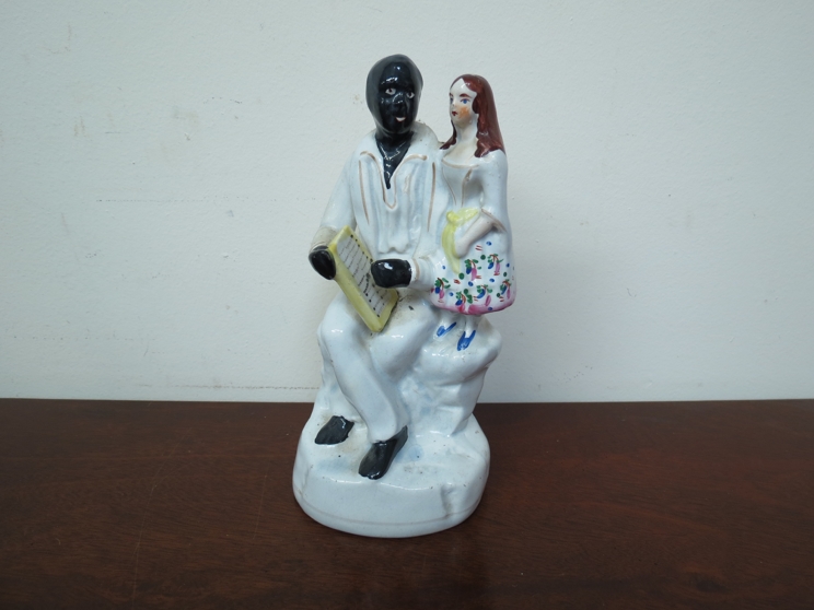 A 19th Century Victorian Staffordshire figure black servant with girl,
