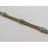A gold double rope twist bracelet set with five canted rectangular pale blue stones,
