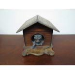 A Victorian cigar box in the form of a dogs kennel with bronze sculpted dog looking outward,