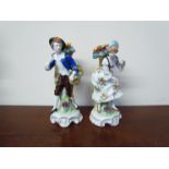 A pair of Sitzendorf porcelain figures "Fruit Sellers" and "Lady & Gentleman with Fruit Basket",