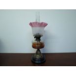 A Victorian oil lamp with English Duplex burner, butterfly decorated frilled shade, glass reservoir,