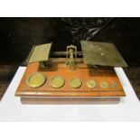 A Victorian oak and brass set of postal scales with six weights