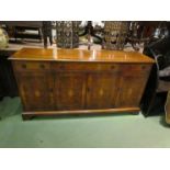 A Georgian style sideboard in the manner of Bevan Funnel the three frieze drawers over four door