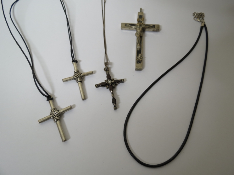 Four various white metal crosses,