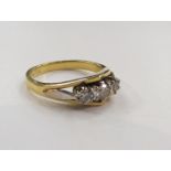 An 18ct gold three stone diamond ring with white gold shoulders