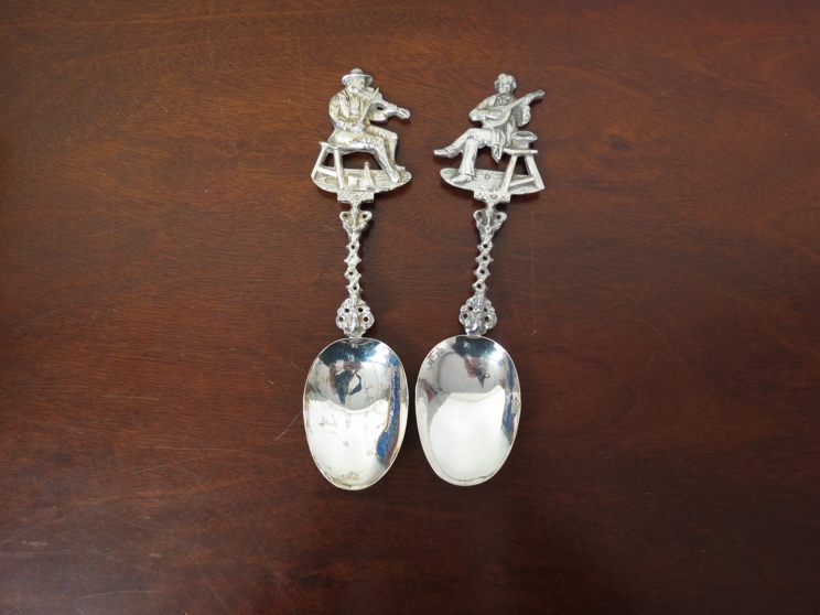 Two ornate silver spoons with musician terminals, import marks for Edwin Thompson Bryant,