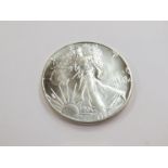 A 1988 US silver liberty dollar,