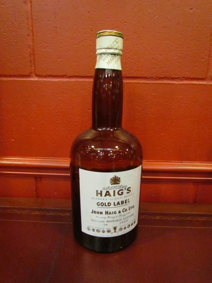 An oversize Haig brown glass whisky bottle