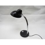 A table lamp with black painted metal down lighter and chromed metal adjustable arm