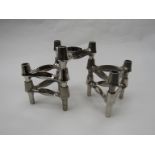 Five modular chromed finish metal B.M.F candleholders.