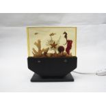 An aquarium table lamp, black painted metal base illuminating a cast resin block. 23cm x 20.