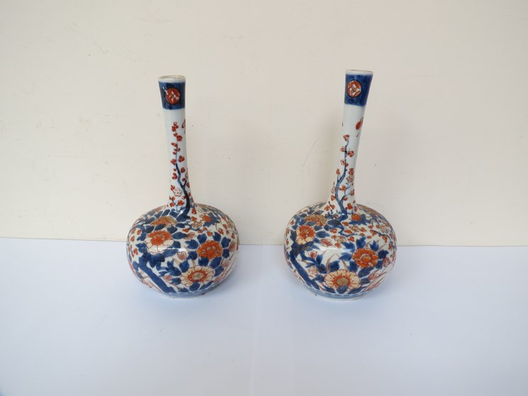 A pair of 19th Century Oriental Imari palette bottle vases with slender necks and floral design,