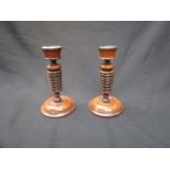 A pair of turned wood candlesticks,