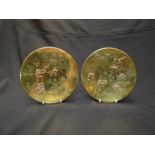 A pair of Oriental brass plaques with applied decoration of figures in external scenes,