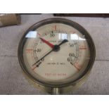 A brass altitude gauge reading lbs² and feet of water