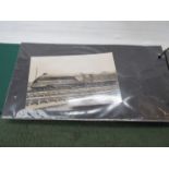 An album containing various black and white and coloured postcards