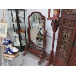 A Victorian mahogany cheval mirror with scroll supports and breakfront base,