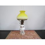 An early 20th Century ceramic owl oil lamp with yellow wrythen form shade 41cm tall