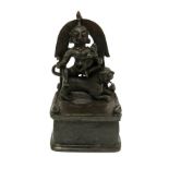 An 18th/19th Century Indian altar bronze as a deity seated on a lion,
