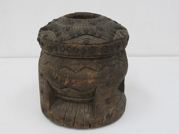 A late 19th Century carved African Mortar with wrought metal studding approximately 22cm tall,