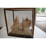 A late 19th Century/ Early 20th Century diorama of Indian temple carved out of soft wood in glass