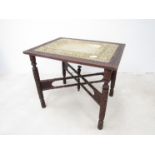 An early to mid 20th Century carved Indian folding table with worked inset brass tray.