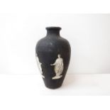 Two late 19th early 20th Century papiermache urns in black, one with etched figures attached,