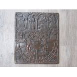 A bronze rectangular sun dial plate depicting medieval style figures in arches and heraldic crest