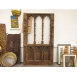 An early 19th Century carved oak ecclesiastical rood screen with three open arches above carved