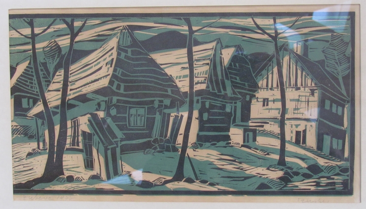 A framed and glazed coloured wood block print. Cottages amongst trees.