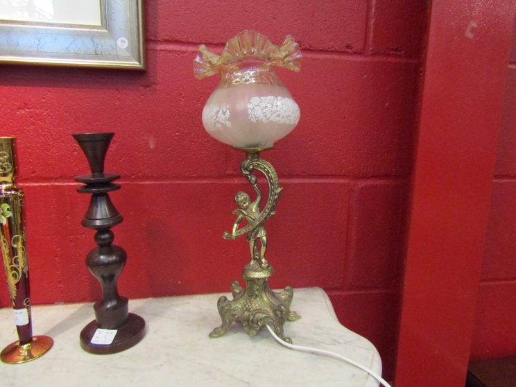 A gilt metal figural lamp with glass shade