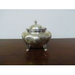 A miniature silver tea caddy of melon form raised on paw feet,