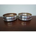 A pair of Mills & Hersey silver wine bottle coaster, hardwood bases,