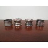 Four silver napkin rings, various makers and dates,