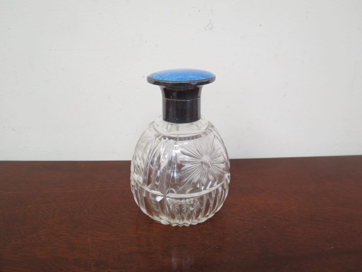 A silver and guilloche lidded scent bottle with crystal glass body,