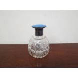 A silver and guilloche lidded scent bottle with crystal glass body,