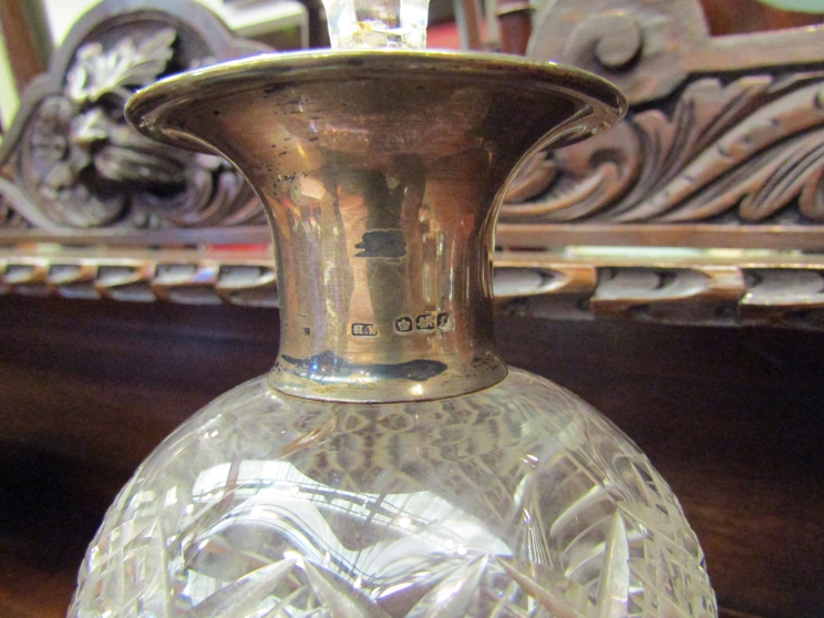 A silver collared crystal glass decanter,