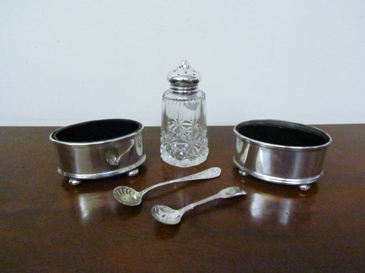 Two silver oval salts with two spoons and a silver topped pepperette,