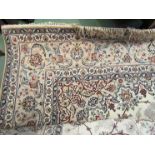 A Persian beige ground wool rug with multiple borders and tasselled ends,