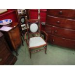 In the Manner of 'Maple and Co' an inlaid mahogany lady's armchair the outswept arms,