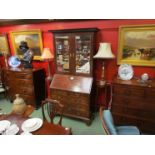 A George II mahogany bureau bookcase, the carved cornice over twin bevelled glass doors.