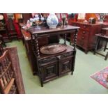 An early Victorian oak two tier serving table with carved mythical sea creature raise back over