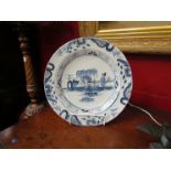 An 18th Century English Delft charger, Oriental figure scene, multiple borders,